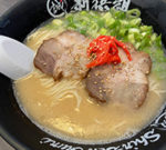 新撰組オリジナル黒いボウルに入った博多ラーメン、白いレンゲがスープに浸っている